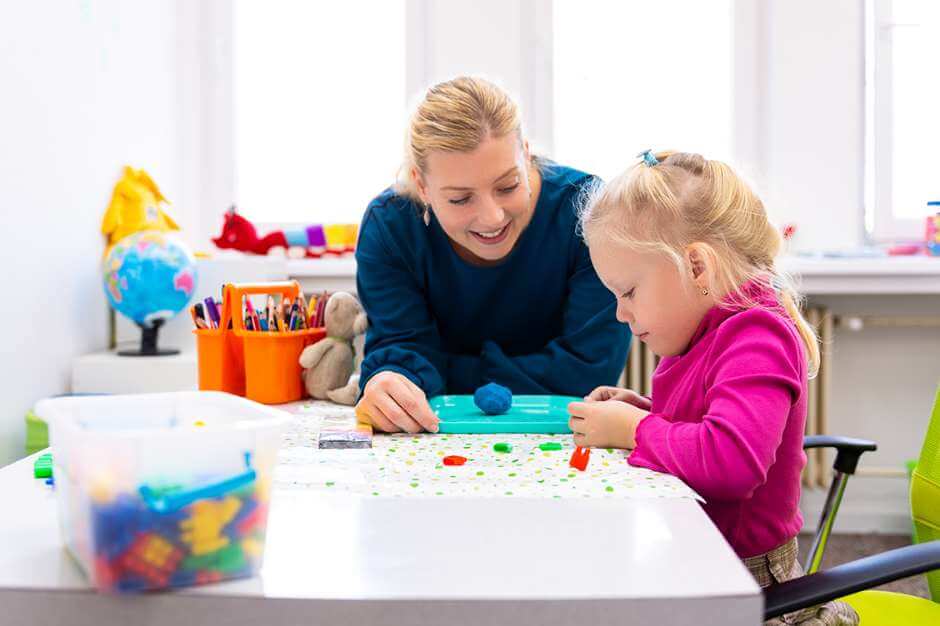 Mother and daughter playing together with a puzzle on a table.