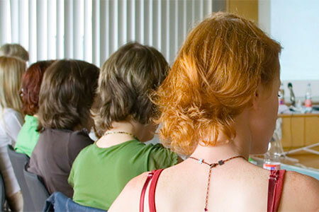 Group of individuals sitting down listening to a teacher.